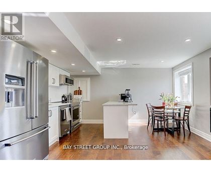 A modern kitchen with stainless steel appliances and a dining table set for four.