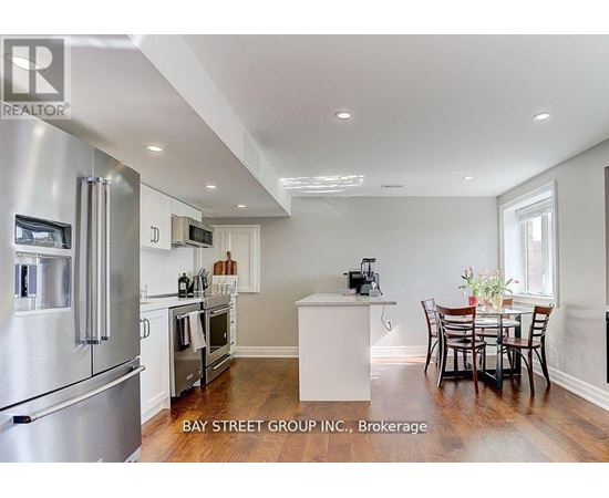 A modern kitchen with stainless steel appliances and a dining table set for four.