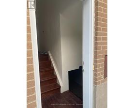 A hallway with a staircase leading to the second floor.