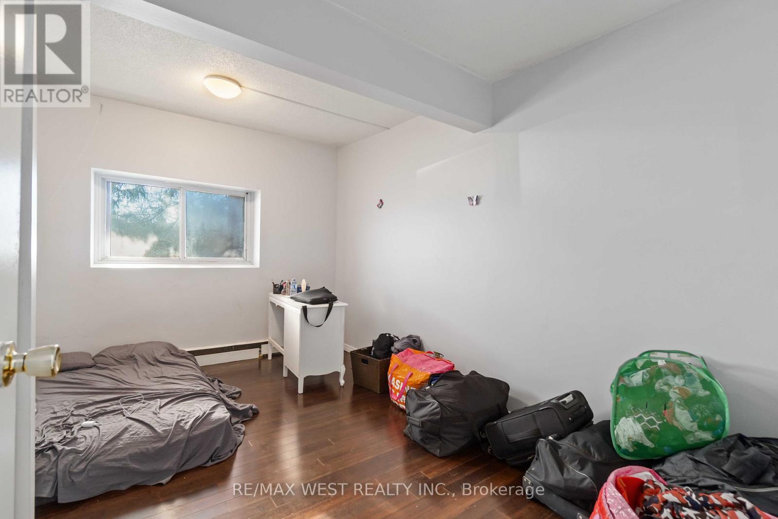 A bedroom with a bed, a small table, and a window.