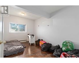 A bedroom with a bed, a small table, and a window.