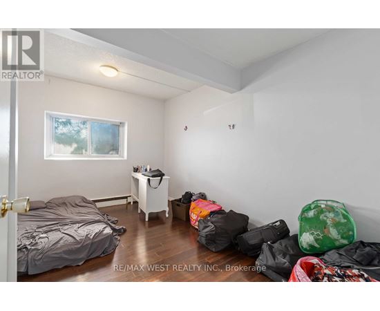 A bedroom with a bed, a small table, and a window.