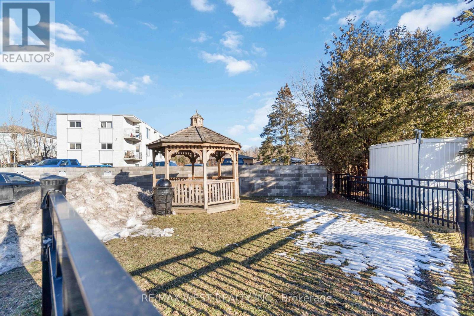 A gazebo sits in a snowy yard.