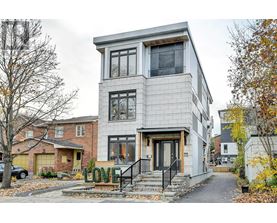 A modern house with a grey facade and a black staircase.