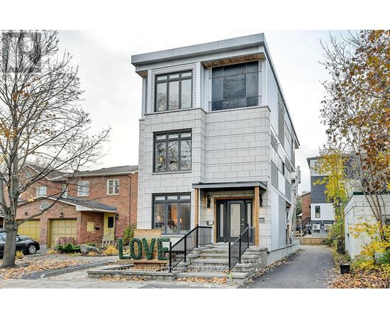 A modern house with a grey facade and a black staircase.