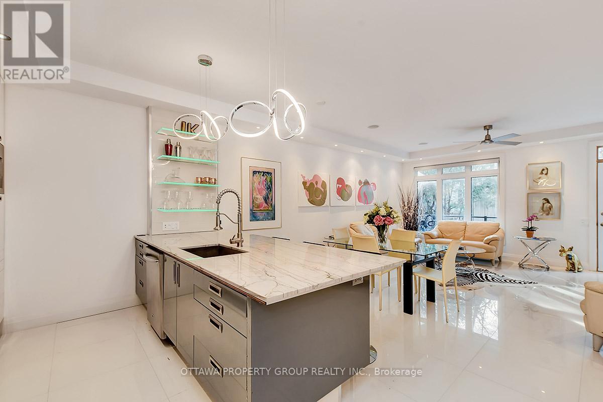 A modern kitchen with a large island and a dining area with a table and chairs.