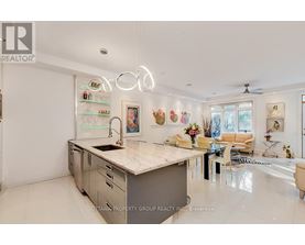 A modern kitchen with a large island and a dining area with a table and chairs.
