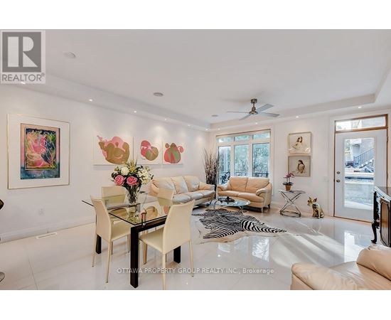 A living room with a glass dining table and chairs.