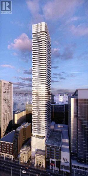 A tall, modern building with a curved design stands in the middle of a cityscape.
