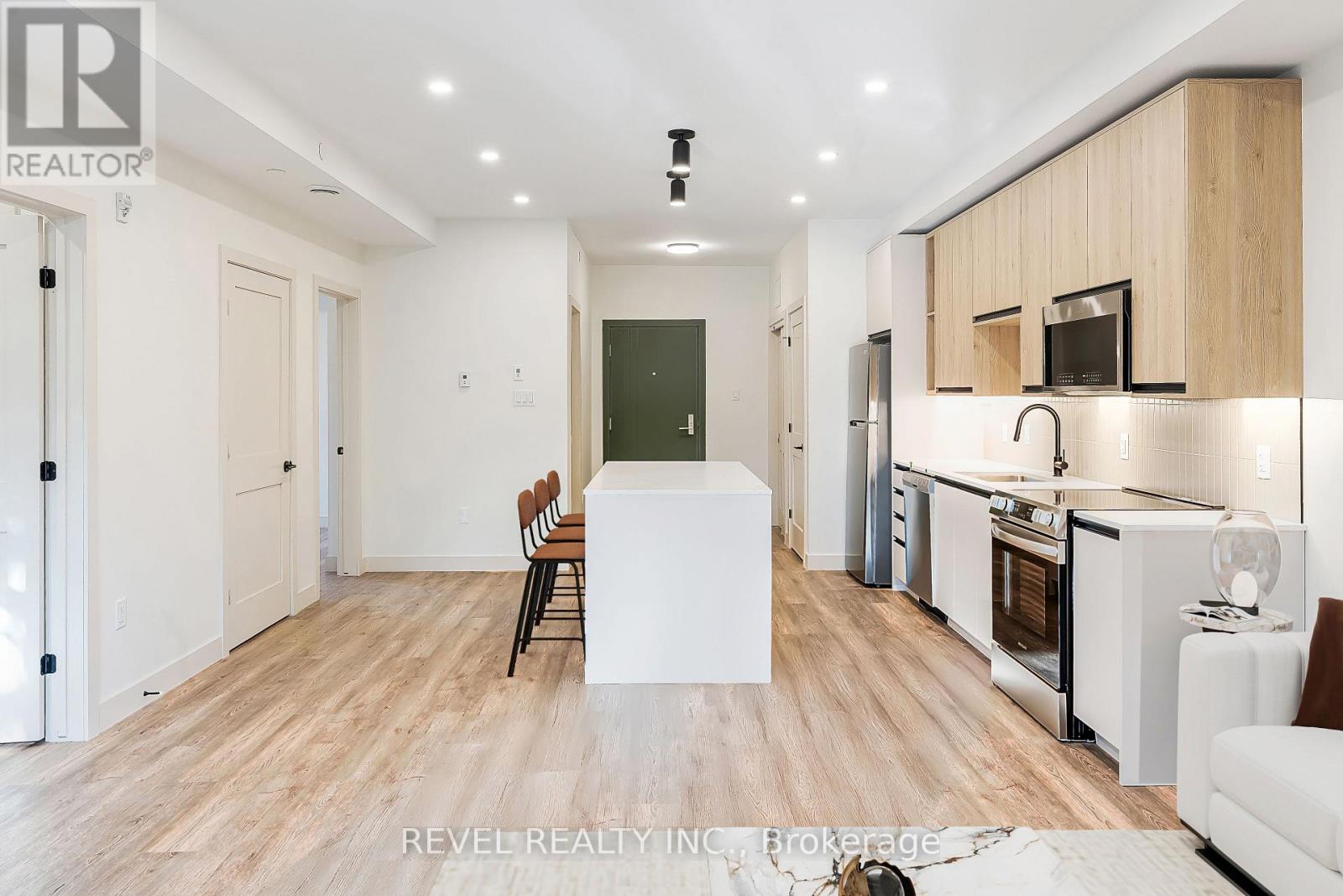 A modern kitchen with wooden floors and white walls.