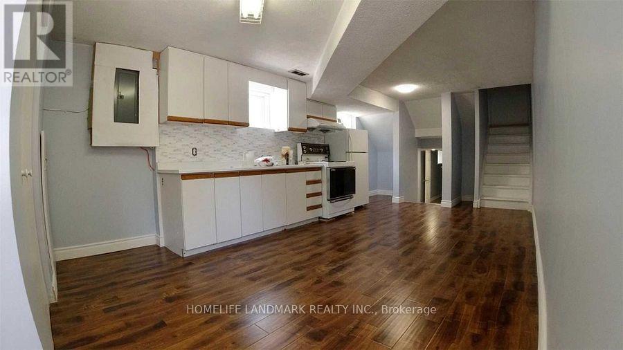 A kitchen with white cabinets and a wooden floor.