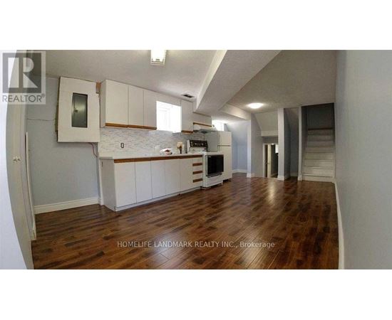 A kitchen with white cabinets and a wooden floor.