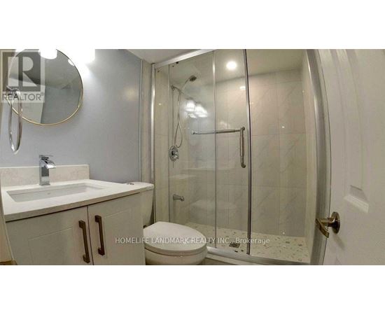 A bathroom with a sink, mirror, and shower.
