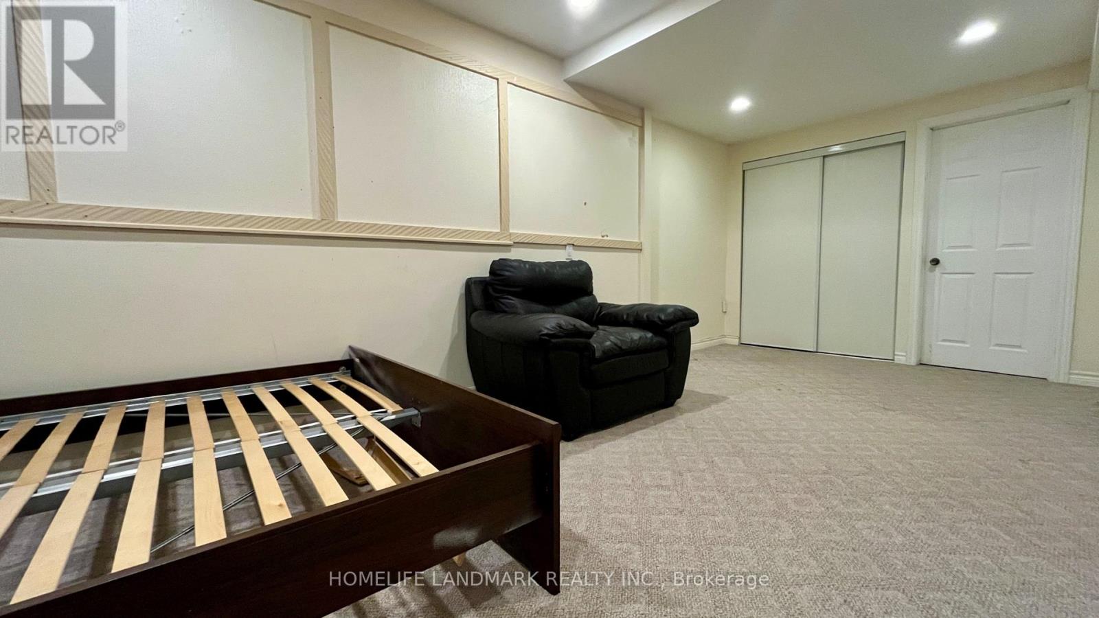 A bedroom with a bed and a black chair.