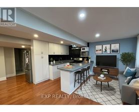 A modern kitchen with a bar area and a living room area.
