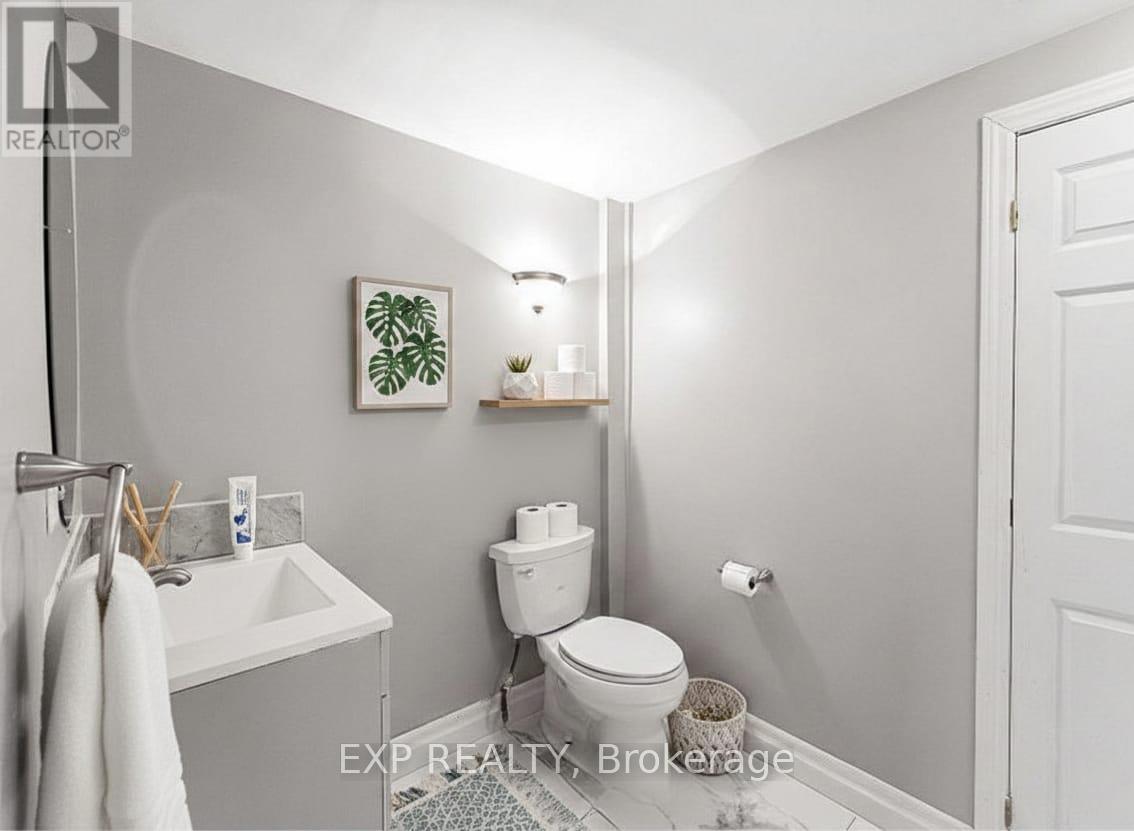 A bathroom with a toilet, sink, and mirror.