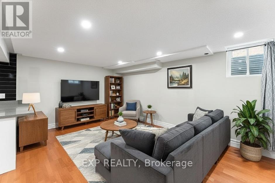 A living room with a grey couch, a wooden coffee table, a television, and a potted plant.