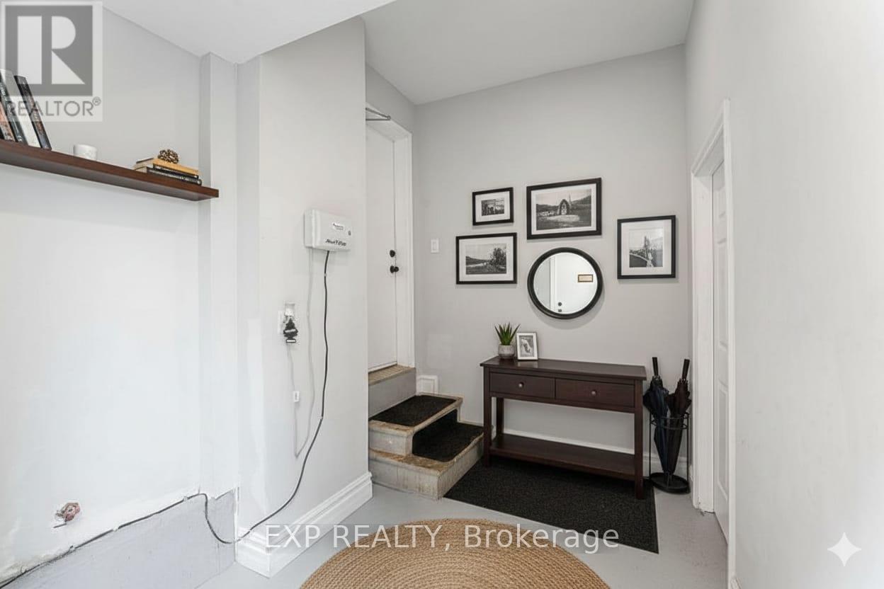 A room with a white wall and a brown bench.