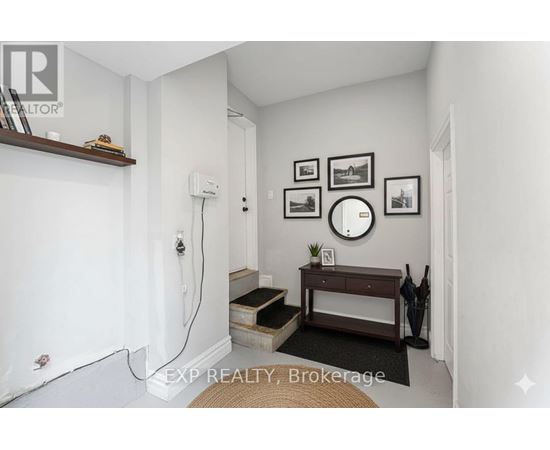 A room with a white wall and a brown bench.
