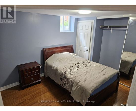 A bedroom with a bed, nightstand, and closet.