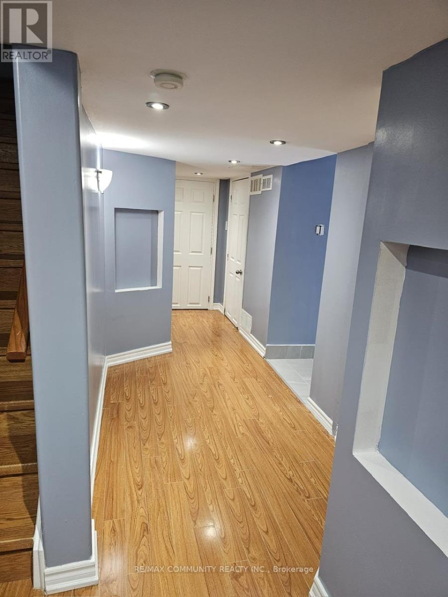A hallway with wood flooring and blue walls.