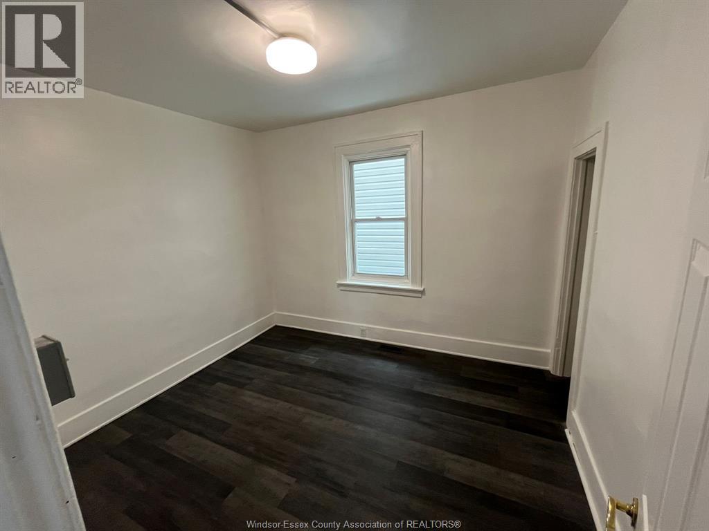 A room with a window and wooden flooring.