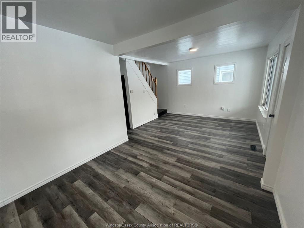 A room with wooden flooring and white walls.