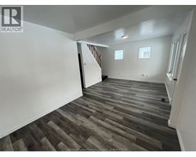 A room with wooden flooring and white walls.