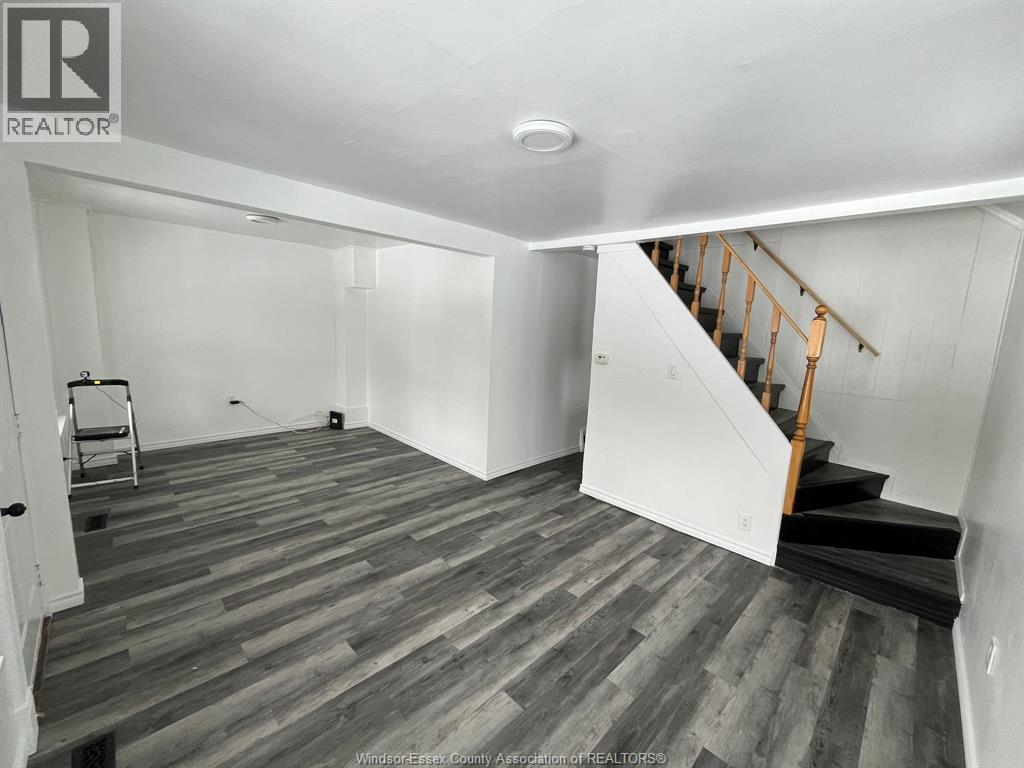 A room with wooden flooring and a staircase.