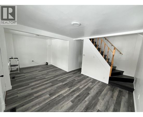 A room with wooden flooring and a staircase.
