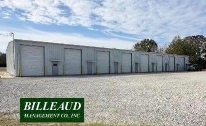 A large white building with the name Billeaud Management Co. Inc. on a sign in front of it.