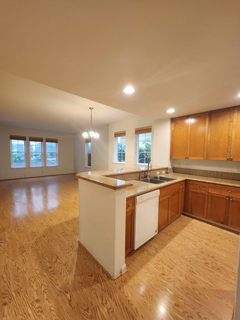 A kitchen with wooden floors and a white dishwasher.