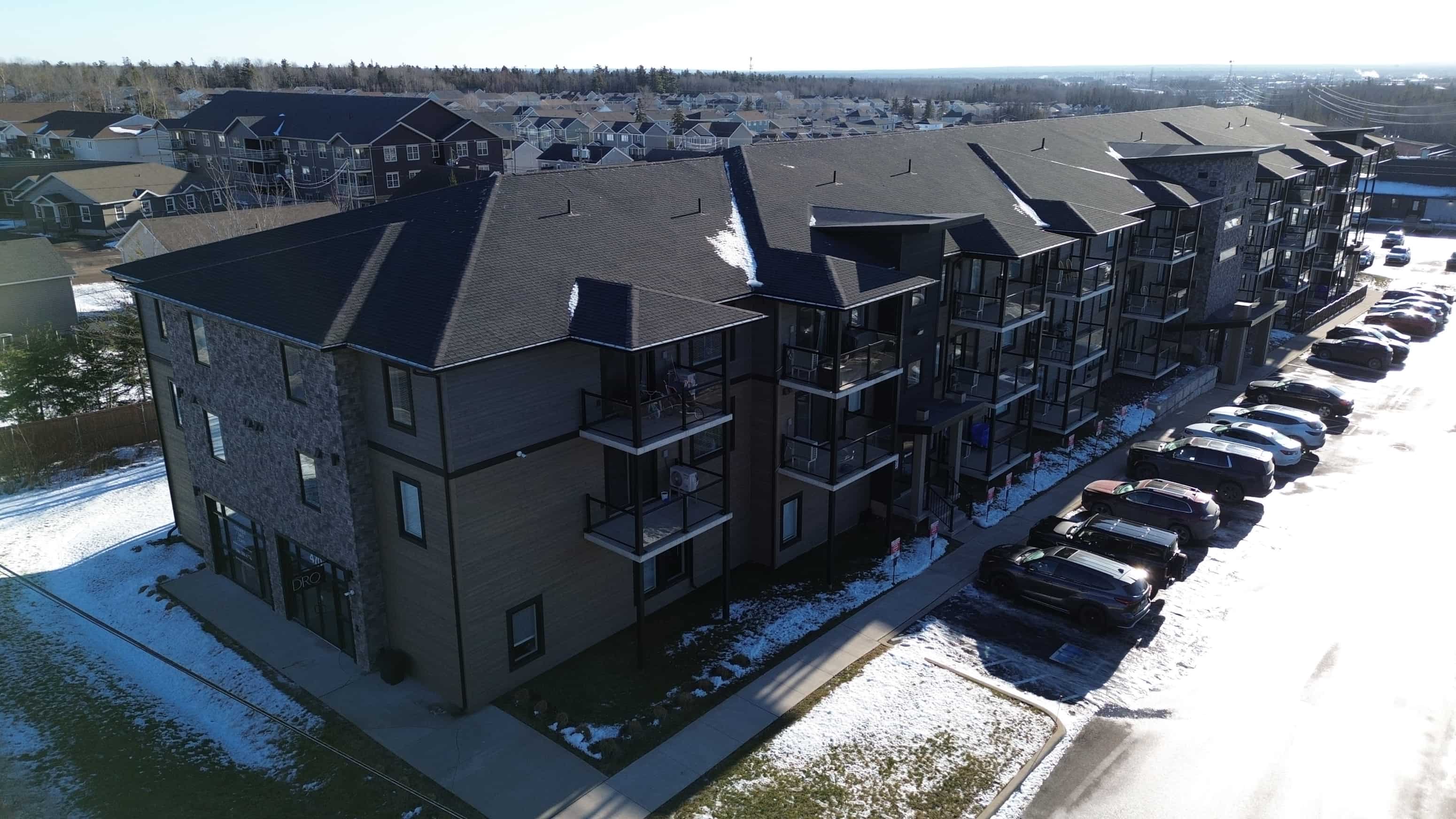 Apartment complex with cars parked in front.