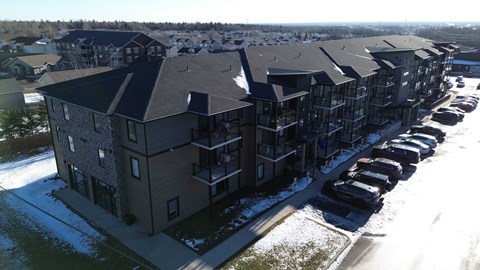 Apartment complex with cars parked in front.