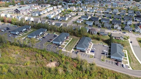 A bird's eye view of a residential area with houses and a parking lot.
