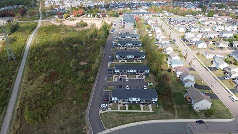 A bird's eye view of a residential area with houses and a road.