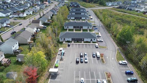 A parking lot with cars and a building in the background.