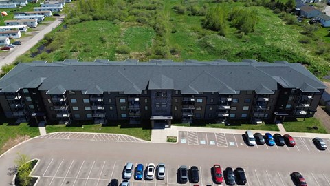 A parking lot with cars and a building in the background.