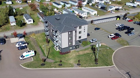 A parking lot with cars and a building in the background.