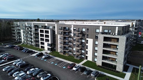 A parking lot in front of apartment buildings.