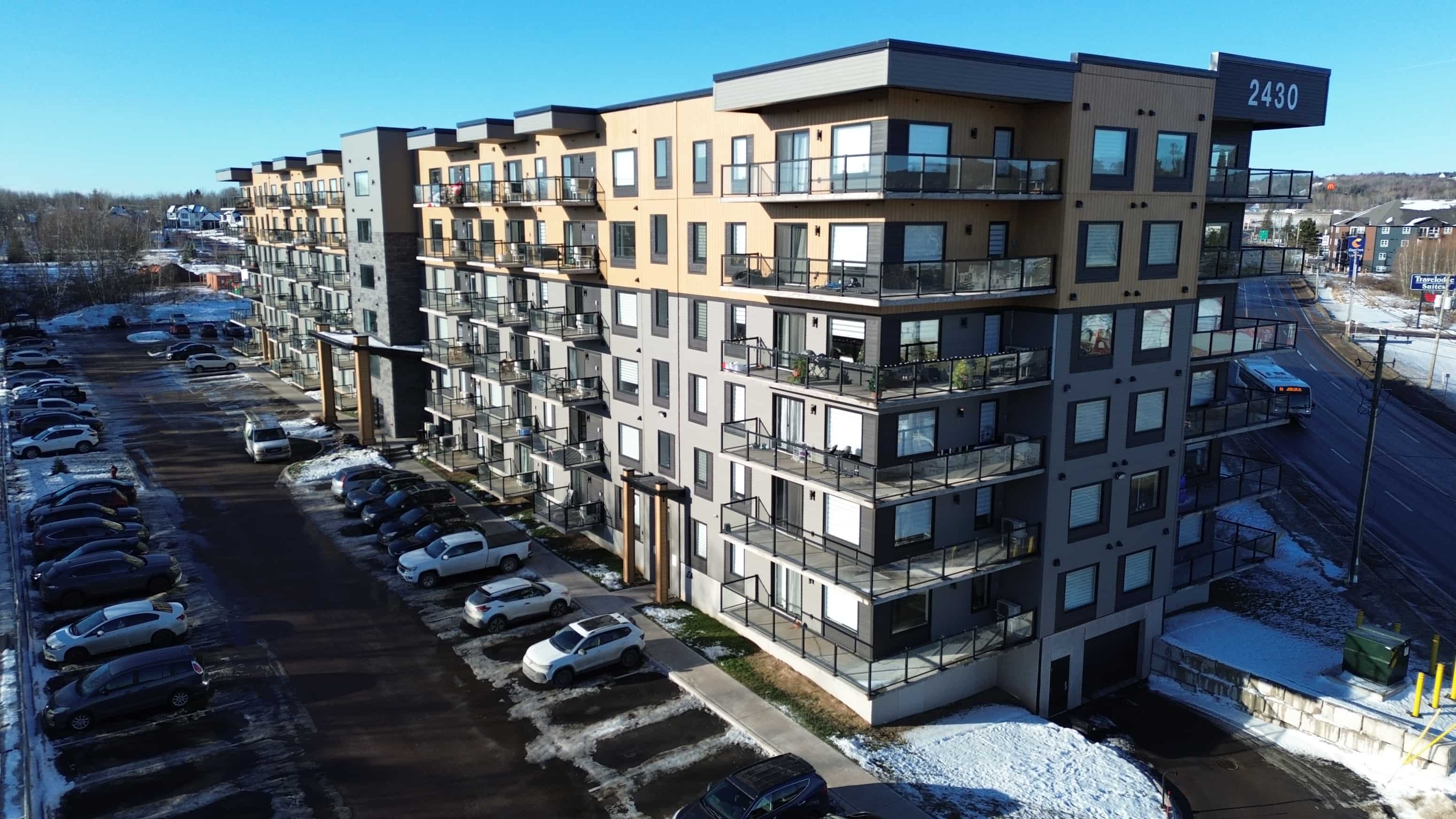 Apartment building 2430 with cars parked in front.