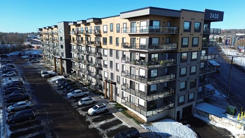Apartment building 2430 with cars parked in front.