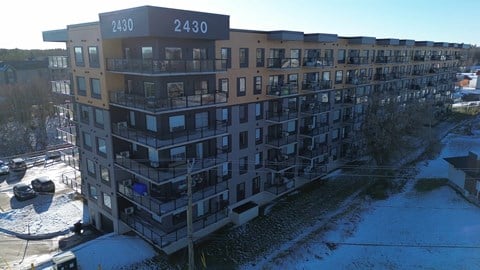 Apartment building 2430 with cars parked in front.