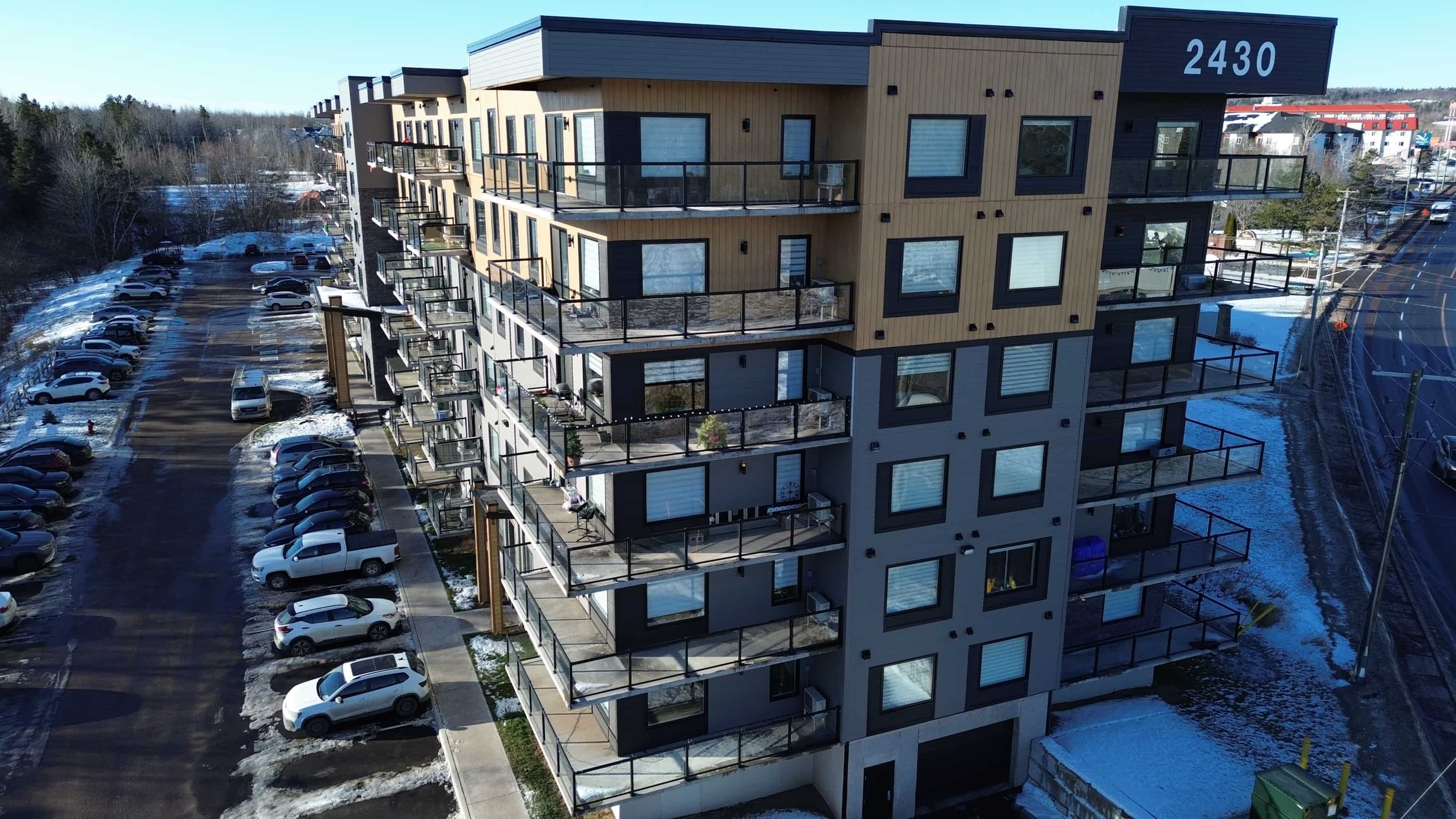 Apartment building 2430 with cars parked in front.