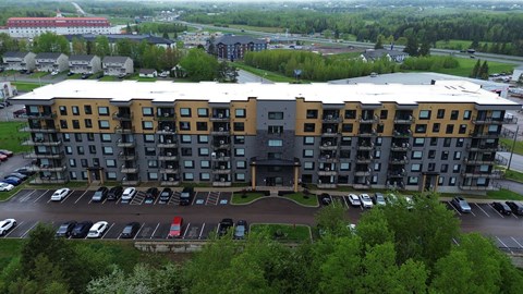 A large multi-story building with a parking lot in front.
