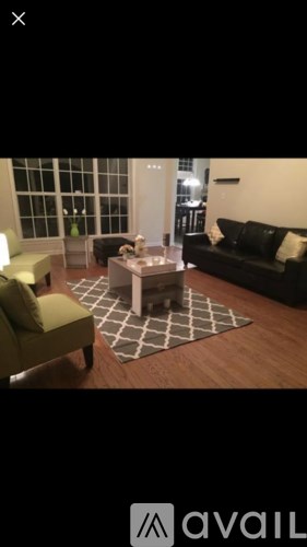 A living room with a black couch and a coffee table.