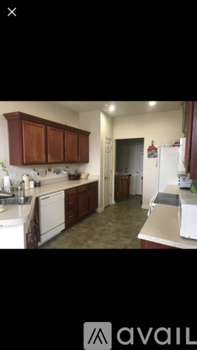 A kitchen with brown cabinets and white appliances.