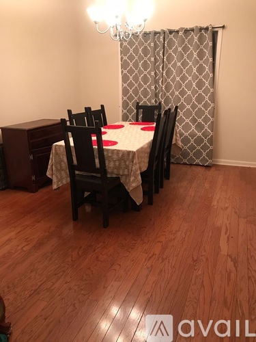 A dining room with a wooden floor and a chandelier.