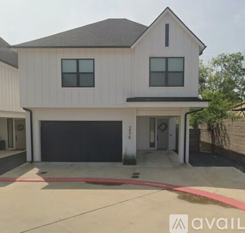 A modern house with a white exterior and a black garage door.