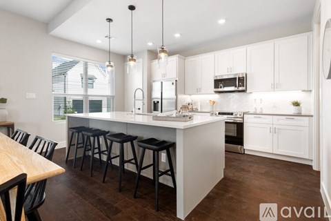 A modern kitchen with white cabinets and a wooden island.
